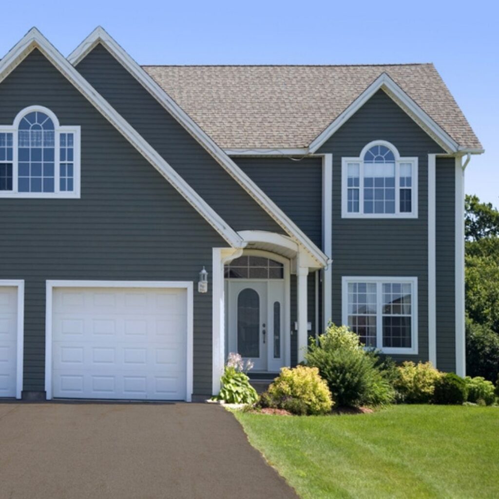 Dark gray two-story house with white garage door