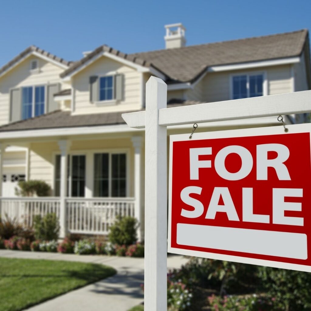 Red For Sale sign in front of yellow house