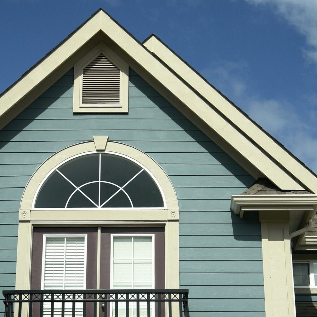 Blue house gable with arched window and white trim
